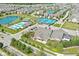Aerial view showcasing community amenities, including a pool, tennis courts, playground, and clubhouse, nestled between scenic ponds at 15304 Fairlands Dr, Westfield, IN 46074