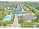Aerial view showcasing community amenities like a pool, tennis courts, playground, and clubhouse, alongside picturesque ponds at 15304 Fairlands Dr, Westfield, IN 46074