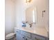Charming powder room featuring blue vanity, brass fixtures, and decorative mirror at 15304 Fairlands Dr, Westfield, IN 46074