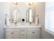 Bright bathroom featuring double vanity with white countertop, stylish mirrors, and updated fixtures at 15304 Fairlands Dr, Westfield, IN 46074