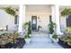 Inviting front porch with elegant columns, planters, and cozy seating at 15304 Fairlands Dr, Westfield, IN 46074