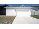 Exterior view of a clean, modern two-car garage with a concrete driveway and green lawn at 15304 Fairlands Dr, Westfield, IN 46074