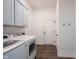 A tidy laundry room with modern appliances and cabinets for storage, leading to a hallway at 15304 Fairlands Dr, Westfield, IN 46074