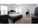 Luxurious main bedroom with tray ceiling, carpeted floors, and dark wood furniture at 15304 Fairlands Dr, Westfield, IN 46074
