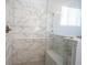 Close up of a marble tiled shower with a glass door and built-in bench, offering a spa-like experience at 15304 Fairlands Dr, Westfield, IN 46074