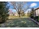 Spacious backyard with green grass, mature trees, and a charming stone retaining wall at 1621 Rosebud Ln, Greenwood, IN 46143
