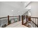 Hallway with decorative wood and iron railing leading to the stairway at 1621 Rosebud Ln, Greenwood, IN 46143