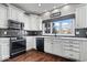 Well-lit kitchen with white cabinets, black appliances, and a dark tile backsplash at 1621 Rosebud Ln, Greenwood, IN 46143