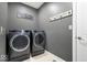 Modern laundry room featuring a front-load washer and dryer with decor on gray walls and tile flooring at 1621 Rosebud Ln, Greenwood, IN 46143