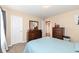 Bedroom featuring neutral walls, carpet, a bed, a dresser with mirror, and a doorway to the hallway at 16406 Taconite Dr, Noblesville, IN 46060
