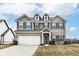 Charming two-story home with brick and vinyl siding, a well-manicured lawn, and an attached two-car garage at 16406 Taconite Dr, Noblesville, IN 46060
