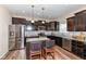 Stylish kitchen boasts stainless steel appliances, granite countertops, and dark wood cabinetry at 16406 Taconite Dr, Noblesville, IN 46060