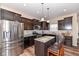 Well-lit kitchen showcasing stainless steel appliances, granite countertops, and dark wood cabinets at 16406 Taconite Dr, Noblesville, IN 46060