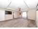 Spacious carpeted main bedroom featuring a ceiling fan, large window with curtains and a tray ceiling at 16406 Taconite Dr, Noblesville, IN 46060