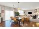 Bright dining area with wood floors, pendant lights over a large table, and comfortable living space at 16736 Workington Way, Westfield, IN 46074