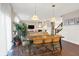 Open-concept dining area featuring a rustic table, modern chairs, and stylish pendant lighting at 16736 Workington Way, Westfield, IN 46074