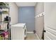 Functional laundry room with modern appliances, storage shelving, and stylish accent wallpaper at 16736 Workington Way, Westfield, IN 46074