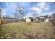 Spacious backyard with grass, leaves, a detached garage, carport and a fire pit at 1711 Kessler E Blvd, Indianapolis, IN 46220