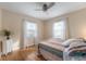 Cozy bedroom featuring natural light from two windows, hardwood floors, and a comfy bed at 1711 Kessler E Blvd, Indianapolis, IN 46220
