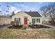 Charming yellow home featuring a red front door and well-kept landscaping at 1711 Kessler E Blvd, Indianapolis, IN 46220