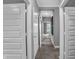 Hallway features paneled doors, gray walls, carpet, and a glimpse of a naturally lit seating area at the end at 181 Cline St, Westfield, IN 46074