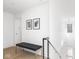 Bright upstairs hallway with a bench seat, black and steel banister and light hardwood floors at 1838 Alabama St, Indianapolis, IN 46202