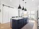 Modern kitchen with a large island, white marble countertops, and a sliding barn door at 1838 Alabama St, Indianapolis, IN 46202