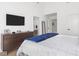 Bright bedroom featuring a dark wood dresser, TV, ensuite access and plush bedding at 1838 Alabama St, Indianapolis, IN 46202