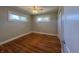 Light-filled bedroom featuring hardwood floors, two windows, and neutral color scheme at 204 W Pullman St, Waldron, IN 46182