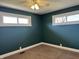 Bedroom featuring neutral carpet, dual windows, and dark blue painted walls at 204 W Pullman St, Waldron, IN 46182