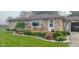 Landscaped front yard with stone accents, garden beds, and quaint seating area at 204 W Pullman St, Waldron, IN 46182