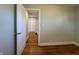 Hallway view of the home interior from a bedroom showcases light walls and hardwood floors at 204 W Pullman St, Waldron, IN 46182