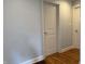 Hallway showcases hardwood floors, white doors, trim, and neutral wall color at 204 W Pullman St, Waldron, IN 46182