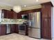 Modern kitchen featuring stainless steel appliances, tile floors, and a chandelier at 204 W Pullman St, Waldron, IN 46182