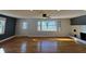 Spacious living room with hardwood floors, fireplace, and natural light from large windows at 204 W Pullman St, Waldron, IN 46182