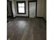 Neutral living room with freshly installed gray, wide-plank laminate flooring and white walls at 238 S Temple Ave, Indianapolis, IN 46201