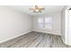 This bedroom has neutral walls, luxury vinyl plank flooring, and a window for natural light at 3026 Everbloom Way, Indianapolis, IN 46217