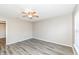 A bedroom features neutral walls, luxury vinyl plank flooring and a window for natural light at 3026 Everbloom Way, Indianapolis, IN 46217