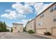 View of beige townhomes featuring two-car garages and a blue cloudy sky at 3052 Skylar Ln, Indianapolis, IN 46208