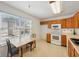 Eat-in kitchen featuring wood cabinets, white appliances, and a bright window overlooking the neighborhood at 3052 Skylar Ln, Indianapolis, IN 46208