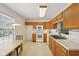 Eat-in kitchen featuring wood cabinets, white appliances, and a sink with a view to the dining room at 3052 Skylar Ln, Indianapolis, IN 46208