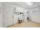 Well-lit laundry room with stacked washer/dryer, utility sink, and storage cabinets for convenience at 3052 Skylar Ln, Indianapolis, IN 46208