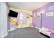 bedroom featuring neutral carpet, a TV, and purple accent wall at 348 W Stop 11 Rd, Indianapolis, IN 46217