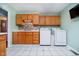 Laundry room in the kitchen, with white tile floors, wooden cabinets, and matching washer and dryer at 348 W Stop 11 Rd, Indianapolis, IN 46217