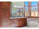 Elegant bathroom vanity with wood cabinets, granite countertop, decorative lighting, and large windows at 3608 Olive Branch Rd, Greenwood, IN 46143
