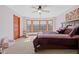 Bright bedroom featuring a bay window, plush carpet, and a wooden door at 3608 Olive Branch Rd, Greenwood, IN 46143