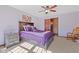 Bedroom features a ceiling fan, purple bedding and a wooden nightstand at 3608 Olive Branch Rd, Greenwood, IN 46143