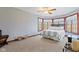 A cozy bedroom features large bay windows, neutral carpet, and modern ceiling fan at 3608 Olive Branch Rd, Greenwood, IN 46143