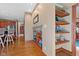 Hallway with hardwood floors, built-in shelves, and views into the kitchen at 3608 Olive Branch Rd, Greenwood, IN 46143