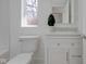 Bathroom featuring a toilet, white vanity with a stone countertop, and a bright window at 3905 N Drexel Ave, Indianapolis, IN 46226